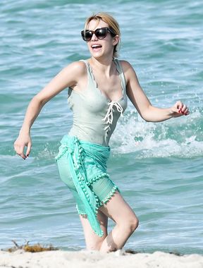 Emma Roberts on the beach in a wet swimsuit
